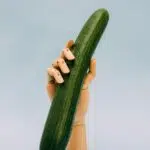 person holding green gourd with artificial hand rack