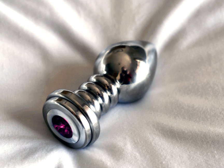 steel anal plug laying on a white background