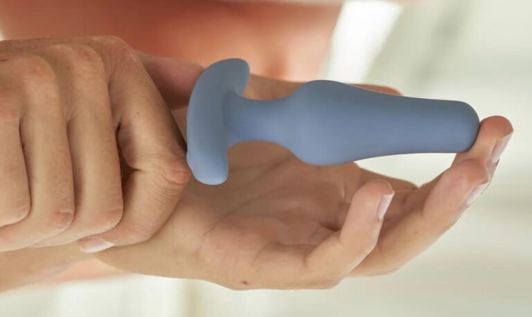 female hands holding a grey butt plug